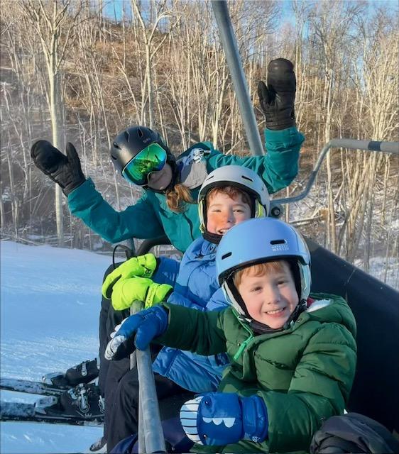 Young children learning to ski at Sugar Mountain Resort in North Carolina with family on a snowy winter day